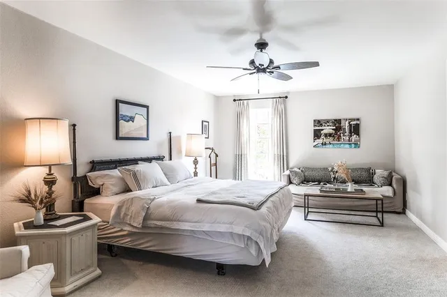 a bedroom with a bed furniture and painting on the wall