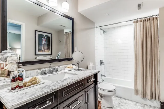a bathroom with a granite countertop sink mirror vanity and toilet