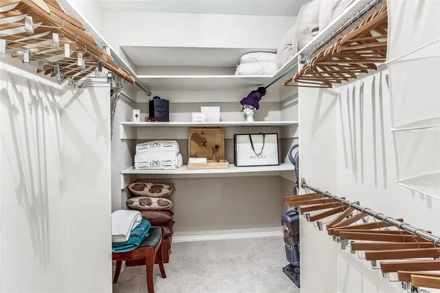 a view of walk in closet with clothes and shoes