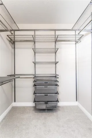 a view of walk in closet with empty racks