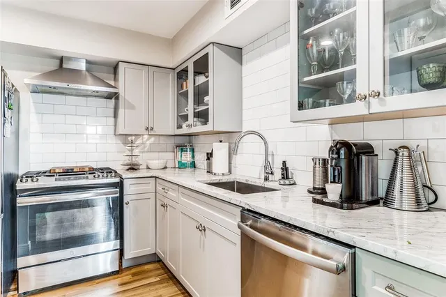 a kitchen with granite countertop a sink stainless steel appliances and cabinets