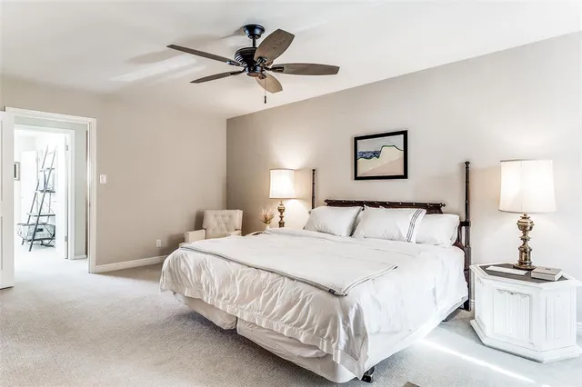a bedroom with a large bed and a chandelier