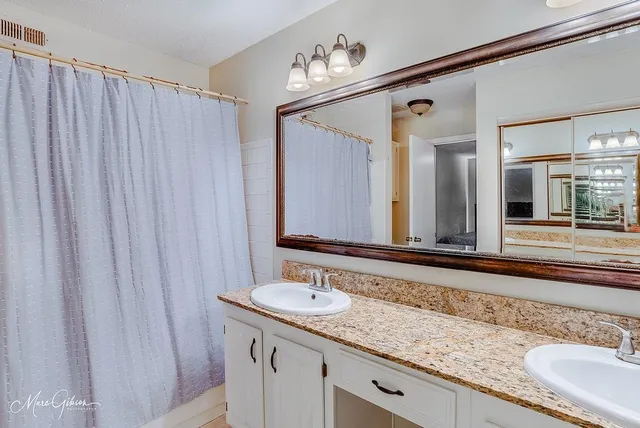 a bathroom with a granite countertop sink and a mirror