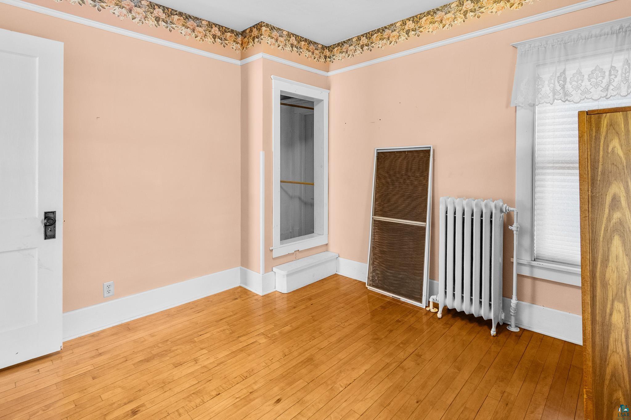 6494 School Street Finlayson, MN 55735 - Photo 11 of 31 Unfurnished room featuring radiator heating unit and hardwood / wood-style flooring