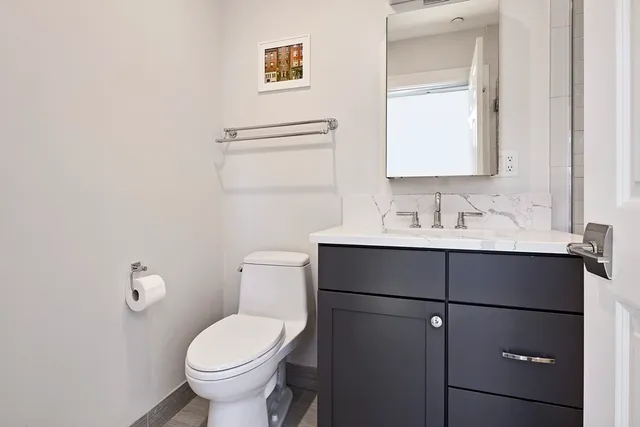 a bathroom with a toilet sink and mirror