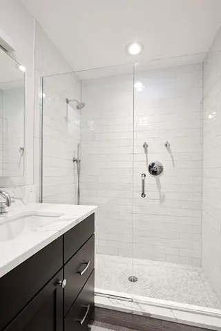 a bathroom with a shower sink vanity and mirror