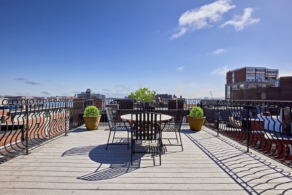 290 North Street, Unit 4 Boston, MA 02113 - Photo 18 of 28 a view of a rooftop deck with chairs and wooden floor