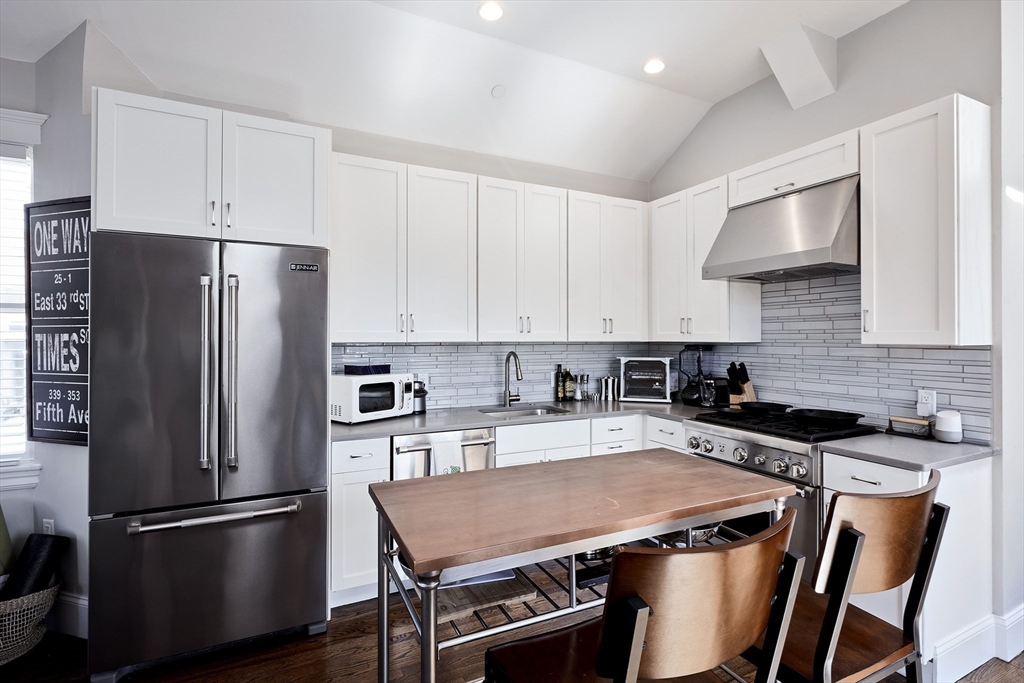 290 North Street, Unit 4 Boston, MA 02113 - Photo 3 of 28 a kitchen with stainless steel appliances a refrigerator a sink a stove a table and chairs