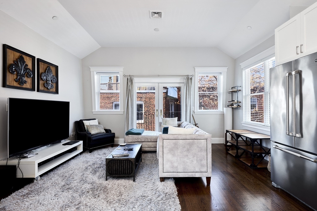 290 North Street, Unit 4 Boston, MA 02113 - Photo 4 of 28 a living room with furniture flat screen tv and a refrigerator