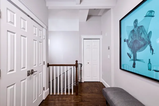 a view of a hallway with wooden floor and closet