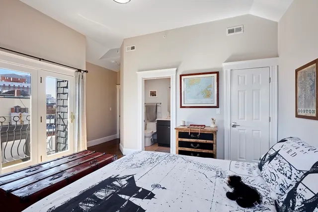 a bedroom with a bed and a large mirror on the dresser