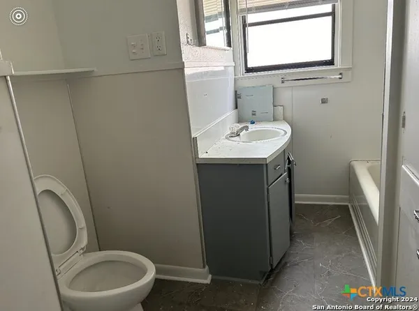 a bathroom with a sink toilet and a mirror