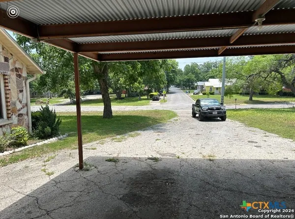 a view of a backyard with table and chairs under an umbrella