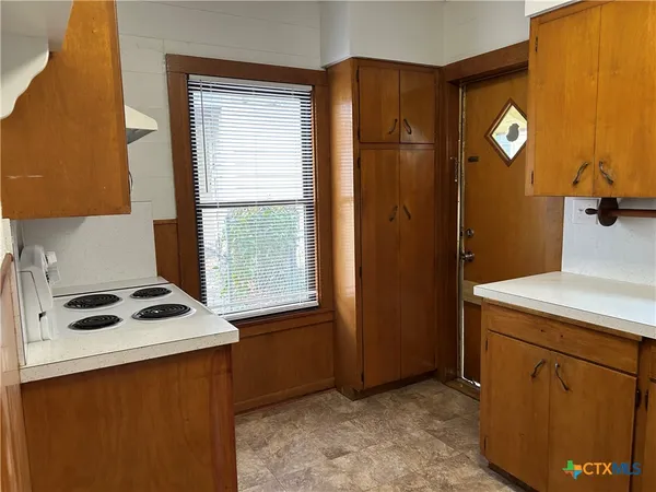 a kitchen that has a sink a stove and a refrigerator