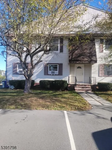 a house that has a tree in front of it