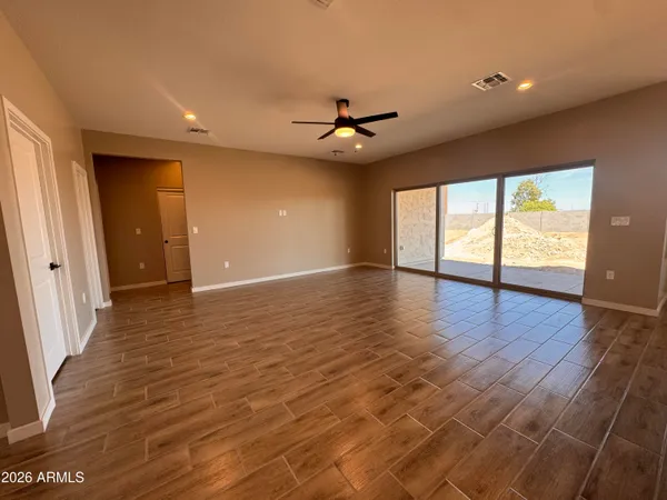 a view of an empty room with window and wooden floor