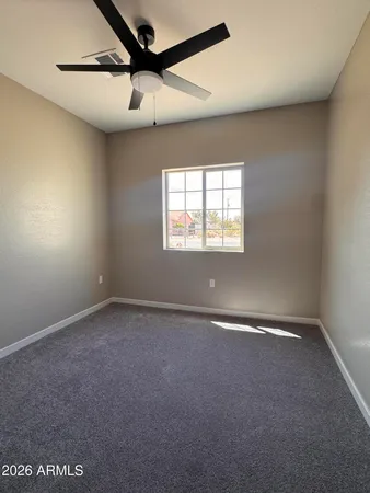 an empty room with windows and fan