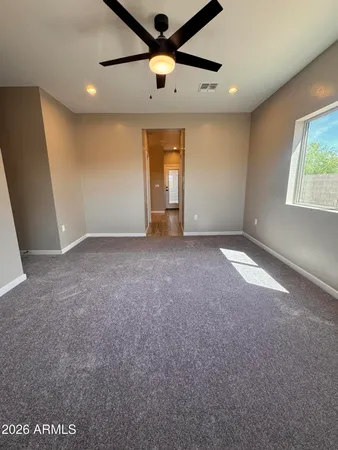 a view of empty room with window and ceiling fan