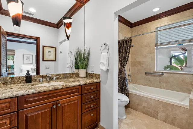 a bathroom with a granite countertop sink a toilet a mirror and shower