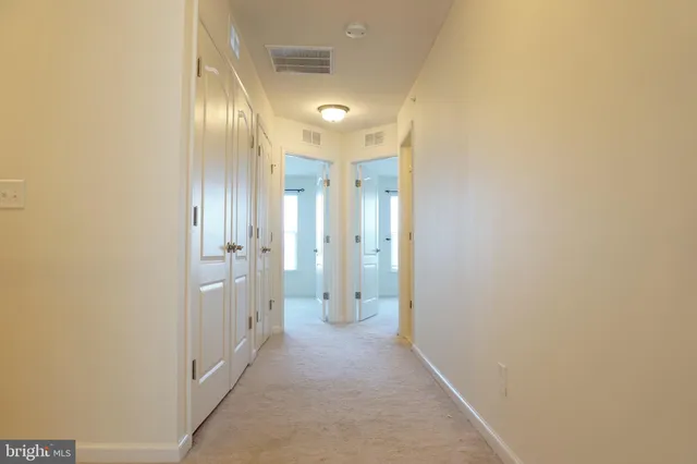 a view of a hallway with wooden shelves