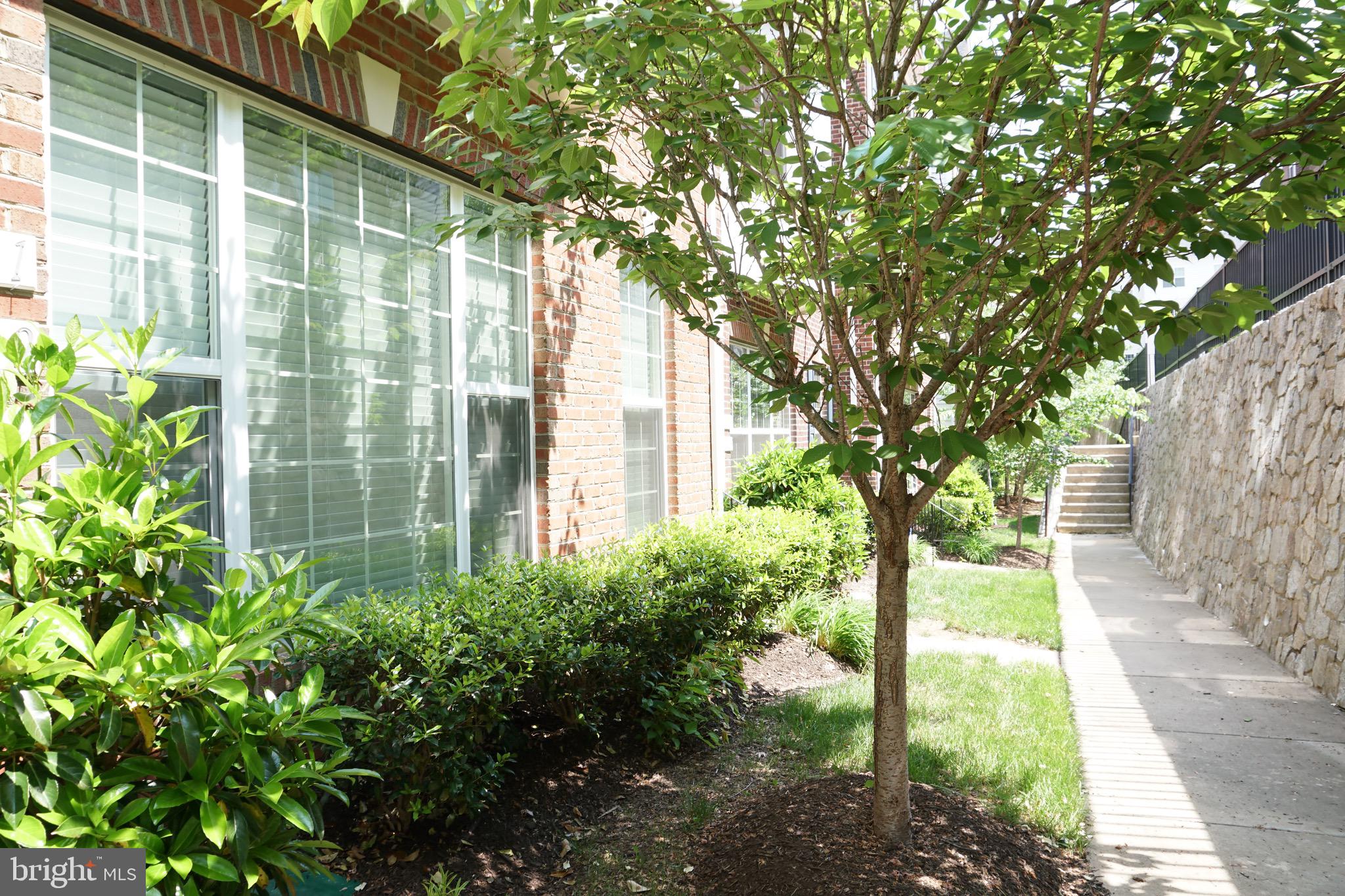 2261 Kew Gardens Drive, Unit 186 Woodbridge, VA 22191 - Photo 31 of 32 a yellow house with flower garden in front of it