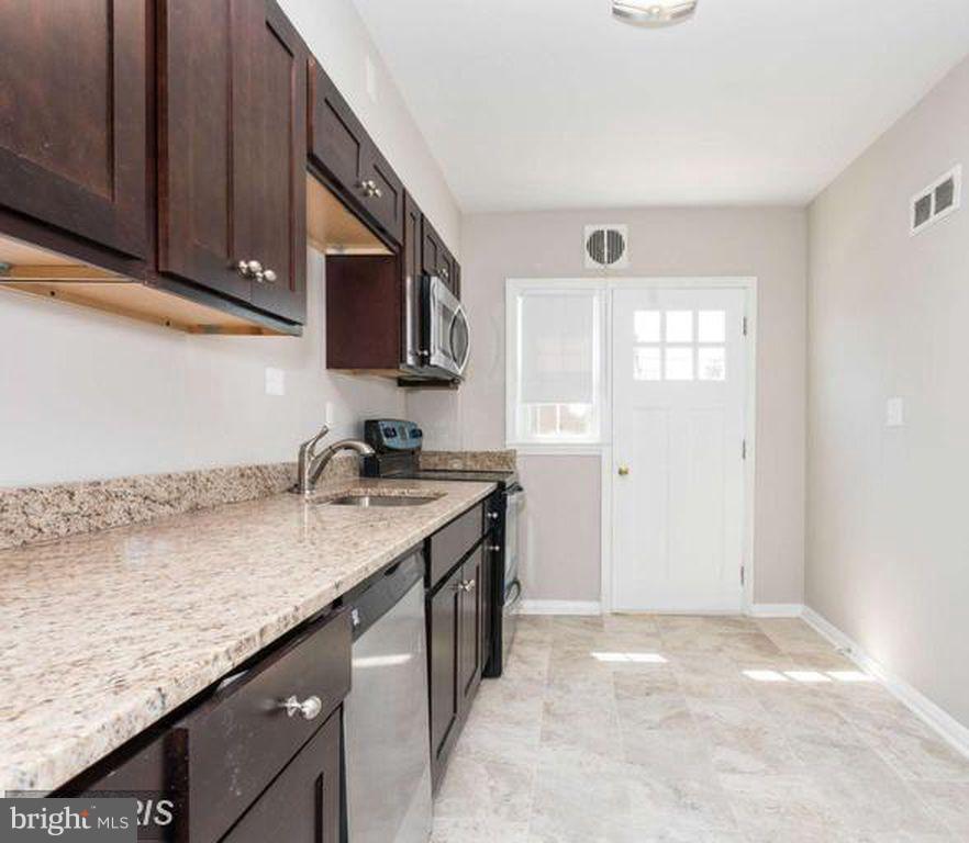 1239 Cedarcroft Road Baltimore, MD 21239 - Photo 2 of 16 a kitchen with granite countertop a sink and a stove