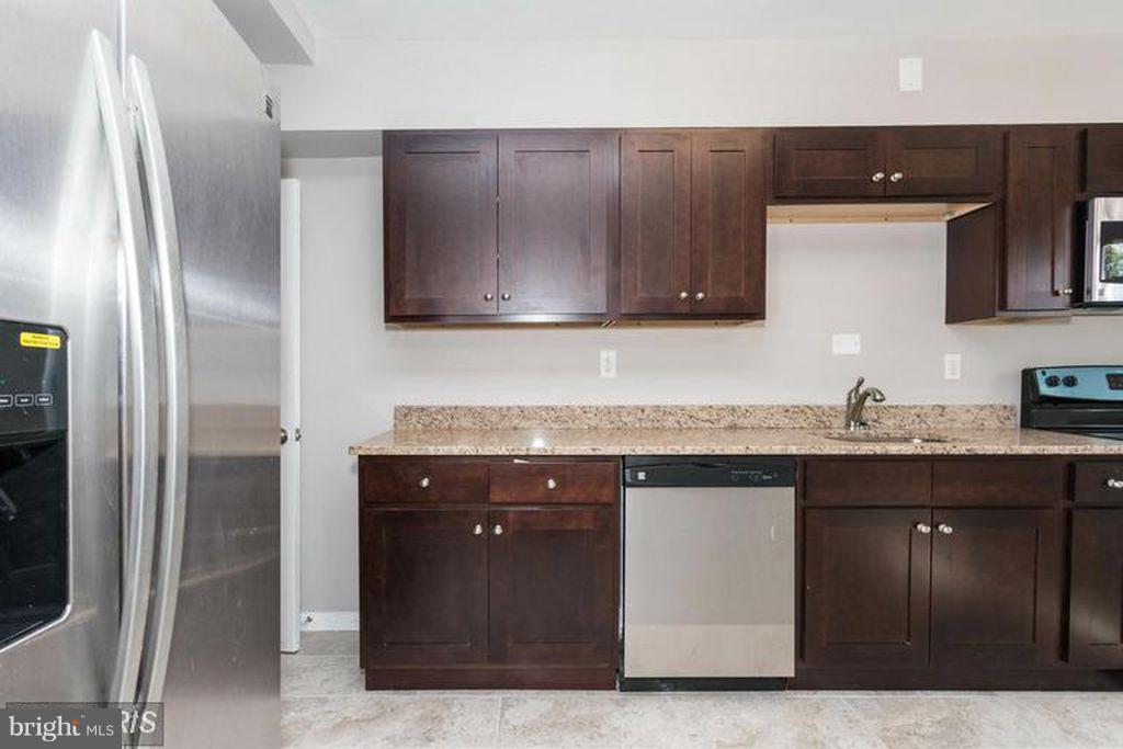 1239 Cedarcroft Road Baltimore, MD 21239 - Photo 3 of 16 a kitchen with granite countertop a sink and cabinets