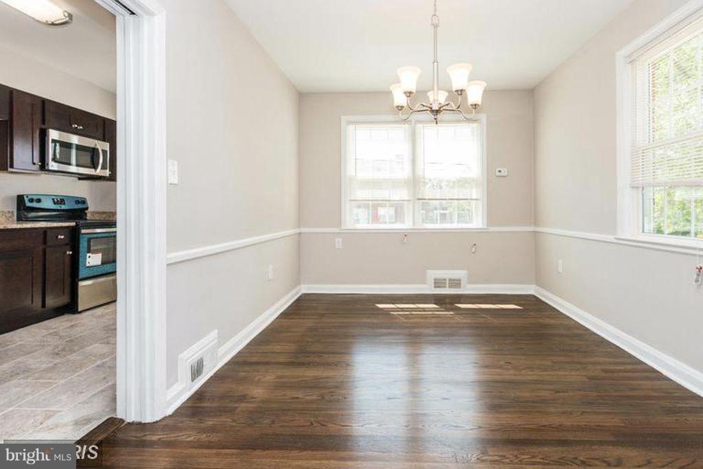 1239 Cedarcroft Road Baltimore, MD 21239 - Photo 4 of 16 an empty room with wooden floor and windows