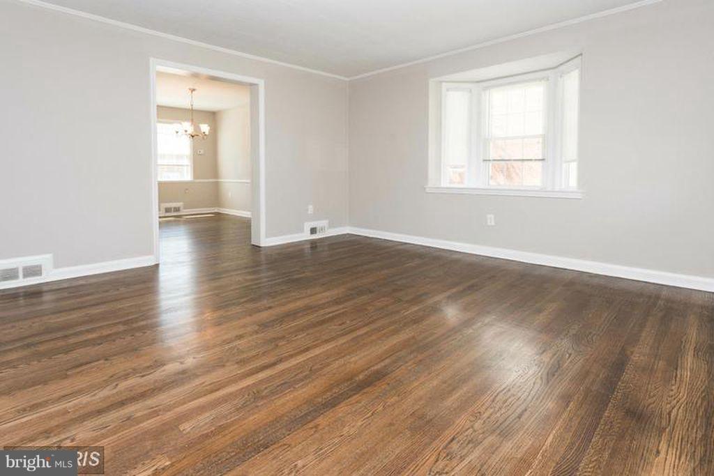1239 Cedarcroft Road Baltimore, MD 21239 - Photo 7 of 16 an empty room with wooden floor and windows