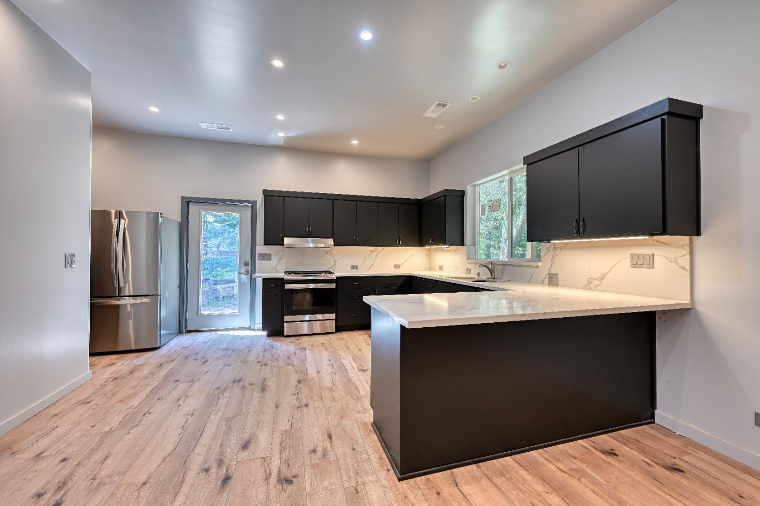 7730 Suzuki Lane Loomis, CA 95650 - Photo 44 of 62 a kitchen with stainless steel appliances kitchen island sink refrigerator and wooden floor