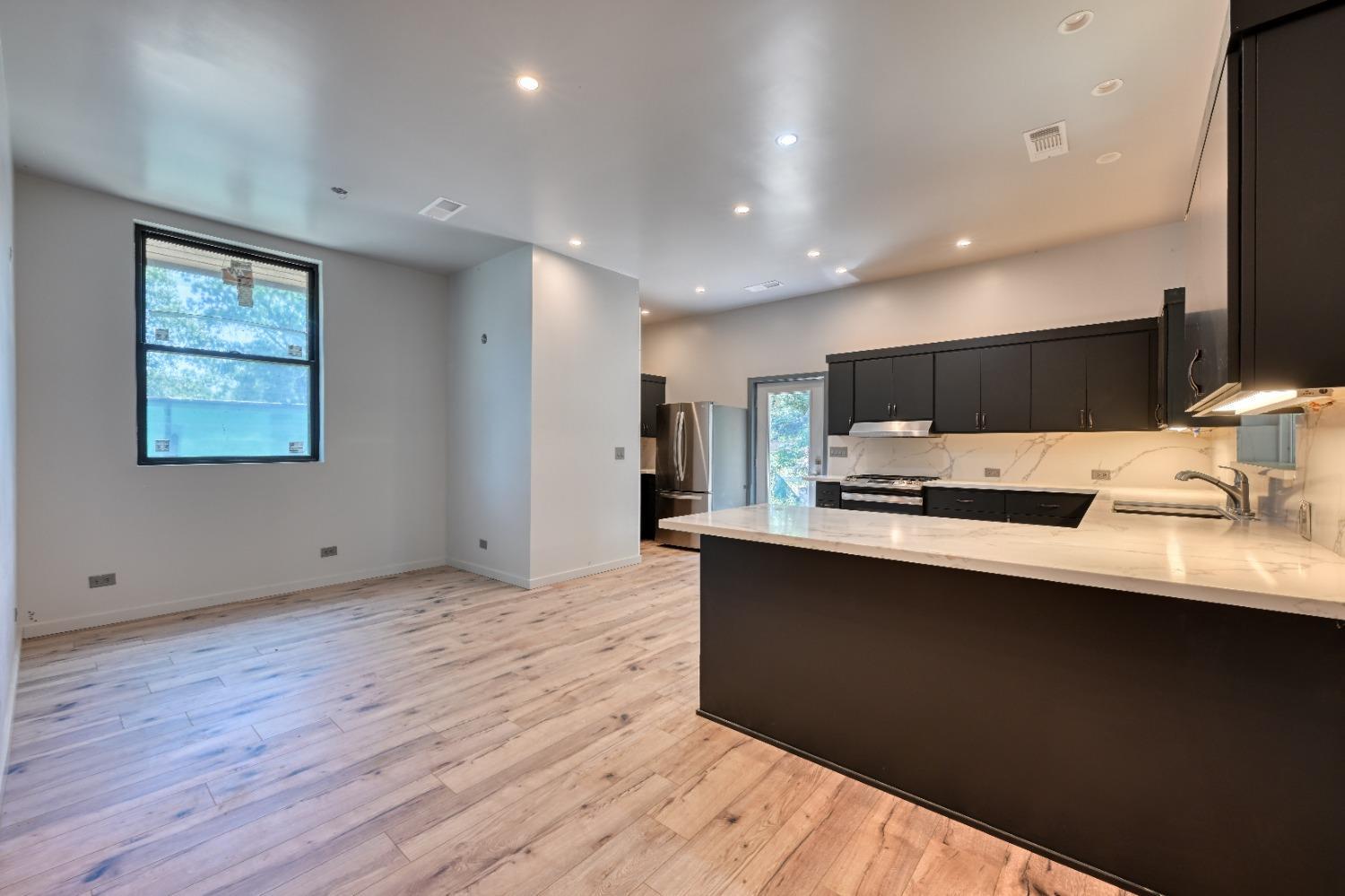 7730 Suzuki Lane Loomis, CA 95650 - Photo 48 of 62 a large kitchen with stainless steel appliances a large counter top a sink a refrigerator and a microwave