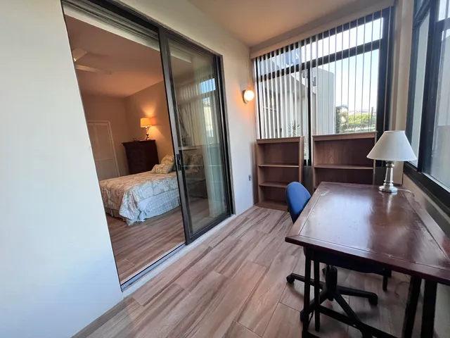 a view of a workspace with furniture and a window
