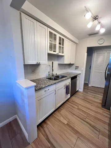 a kitchen with granite countertop wooden cabinets and a sink
