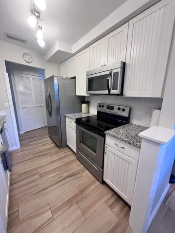 a kitchen with stainless steel appliances a stove microwave and refrigerator