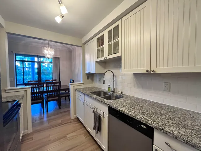 a kitchen with stainless steel appliances granite countertop a sink stove and cabinets