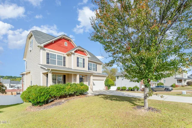 a front view of a house with a yard and lake view