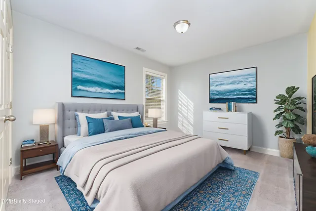 a bedroom with a large bed plant and a window