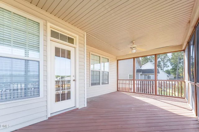 a view of a porch with wooden floor and floor to ceiling window