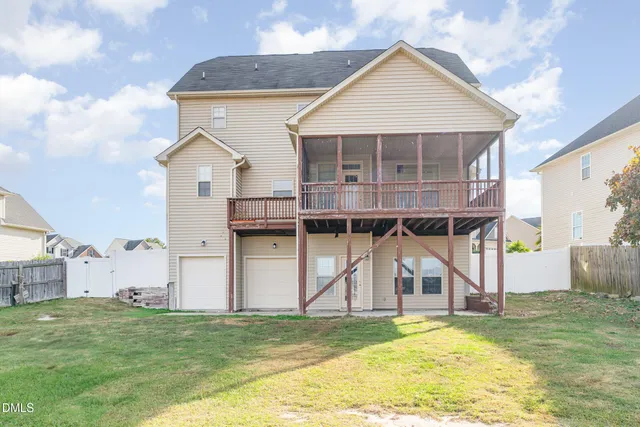 a view of a big house with wooden fence