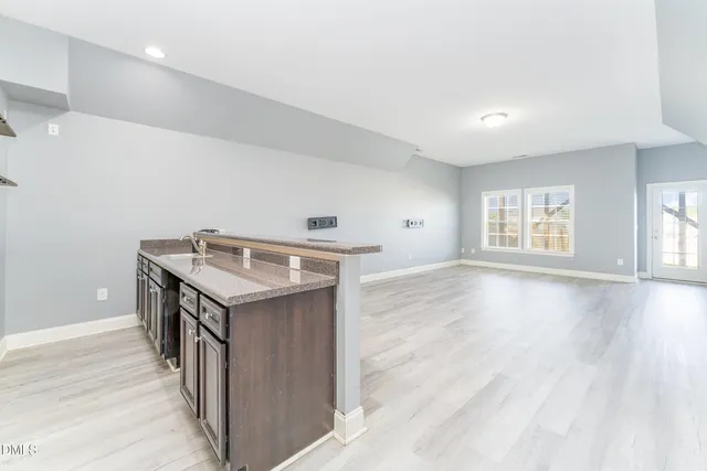 a kitchen with refrigerator cabinets and wooden floor