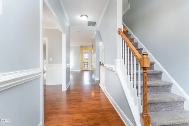 a view of a hallway with wooden floor and staircase