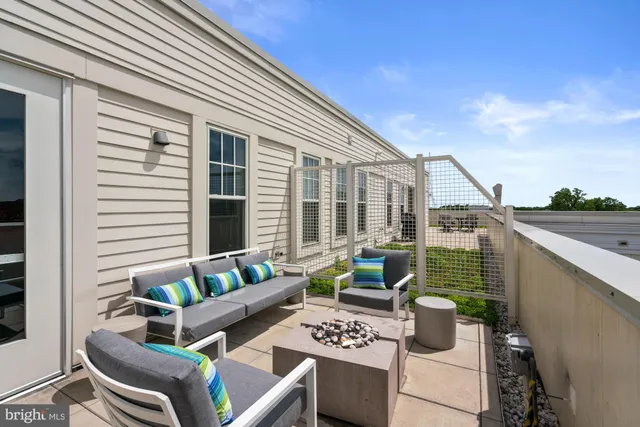 a living room with furniture a flat screen tv and kitchen view
