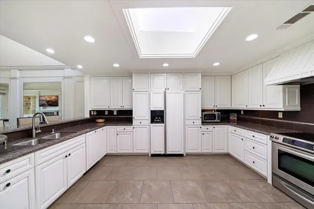 a large kitchen with stainless steel appliances and white cabinets