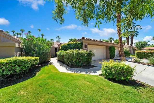 a view of a house with a yard and potted plants