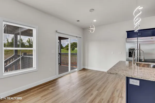 a view of kitchen with granite countertop window and wooden floor