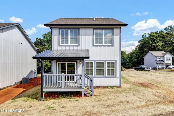 a view of a house with a yard and wooden fence