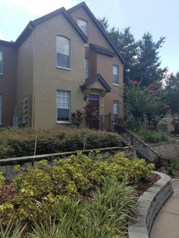6304 Raleigh Street, Unit 202 Orlando, FL 32835 - Photo 2 of 15 a front view of a house with a yard
