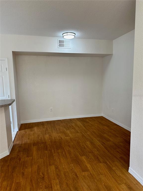 6304 Raleigh Street, Unit 202 Orlando, FL 32835 - Photo 5 of 15 a view of an empty room with wooden floor and a window