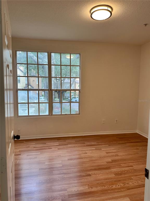 6304 Raleigh Street, Unit 202 Orlando, FL 32835 - Photo 7 of 15 a view of an empty room with wooden floor and a window