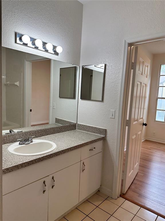 6304 Raleigh Street, Unit 202 Orlando, FL 32835 - Photo 8 of 15 a bathroom with a sink a large mirror and a vanity